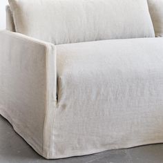 a white couch sitting on top of a cement floor