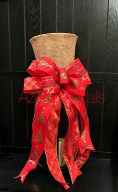 a red bow tied to the back of a burlock with gold designs on it