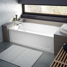 a white bath tub sitting next to a window