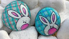 two painted rocks sitting on top of white rocks