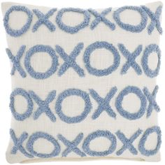 a blue and white pillow with an embroidered design on the front, in two different colors