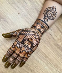 a woman's hand with henna tattoos on it