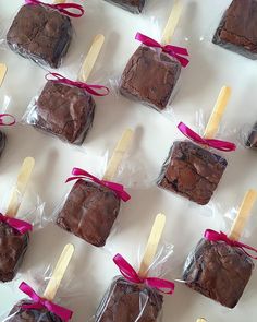 chocolate brownies wrapped in cellophane and tied with pink ribbon on white table