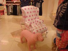 a pink and white polka dot chair in a store