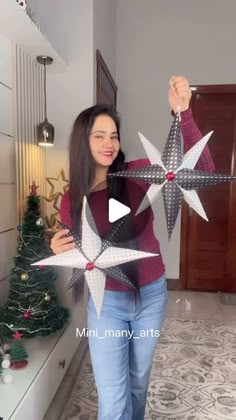 a woman is holding up some paper stars