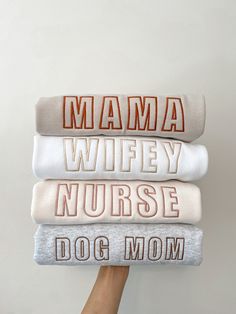 a person holding three blankets with the words mama, wife, nurse and dog mom on them