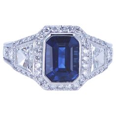 a blue sapphire and diamond ring with white diamonds on the sides, set in 18k white gold