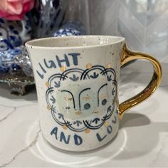 a white and gold coffee cup sitting on top of a table