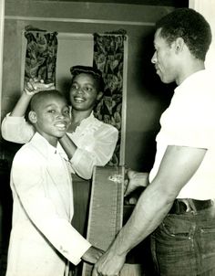 a black and white photo of two people standing next to each other, one holding the door handle