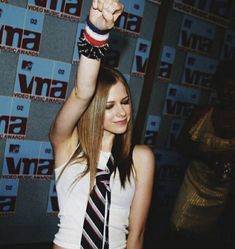 a woman wearing a tie and holding her fist up