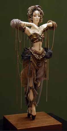 a statue of a woman with chains around her neck and hands in the air, on top of a wooden platform