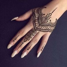 a woman's hand with henna tattoos on it