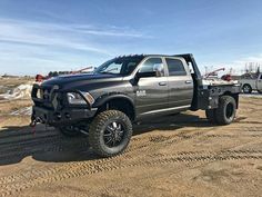 a large gray truck parked on top of a dirt field