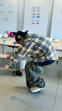 a young man riding a skateboard on top of a cement floor next to a wooden table