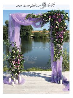 an outdoor wedding set up with purple and white flowers on the altar, along with candles