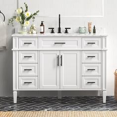 a white bathroom vanity with two sinks and some flowers on the counter top in front of it