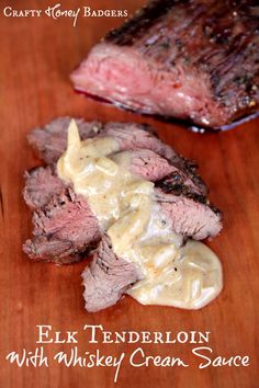 steak with whiskey cream sauce on a cutting board next to another piece of meat that has been grilled