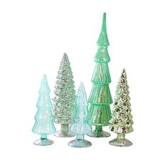 small glass christmas trees are lined up against a white background