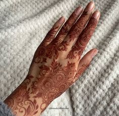 a woman's hand with henna on it