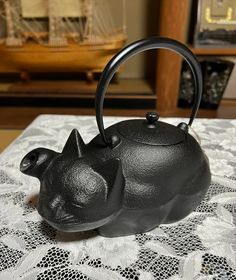 a teapot shaped like a cat on a table