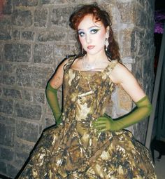 a woman in a dress and gloves posing for the camera