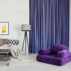 a living room with purple curtains and furniture