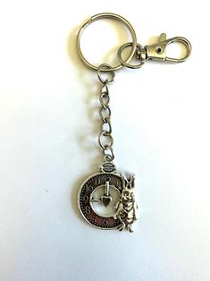 a metal key chain with an elephant and letter g on it's center piece