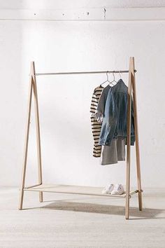 a clothes rack with two shirts hanging on hangers and shoes in the foreground