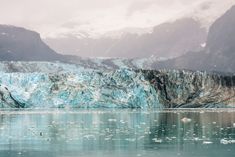 an iceberg with mountains in the background