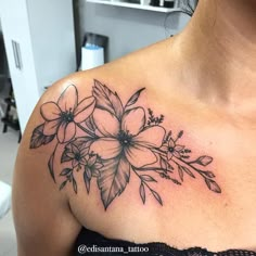 a woman with a tattoo on her chest has flowers and leaves in the middle of it