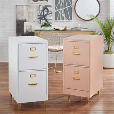 two pink and white filing cabinets sitting on top of a hard wood floor next to a potted plant