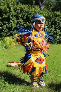 a little boy dressed up in a colorful costume