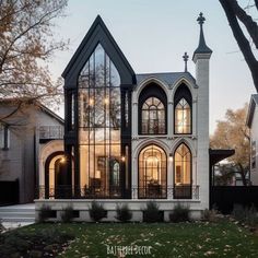 a large white and black house with lots of windows in the front yard at dusk