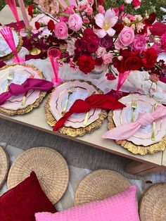 a table topped with plates and pink flowers