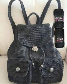 a crocheted black purse sitting on top of a white couch