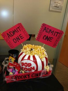 a popcorn bucket with some signs on top of it that say admit one and pop corn