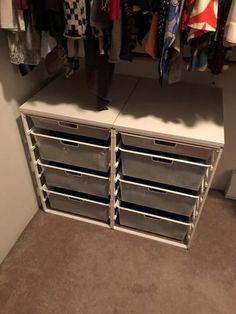 an organized closet with drawers and hanging clothes