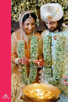 two people standing next to each other in front of a cake