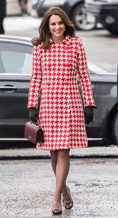 a woman in a red and white coat is walking down the street