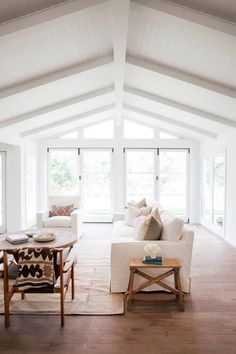 a living room filled with furniture and windows