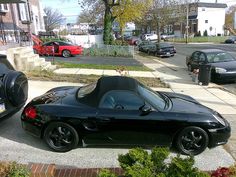 a black sports car parked in front of a house