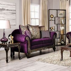 a living room filled with purple furniture in front of two windows and a rug on the floor