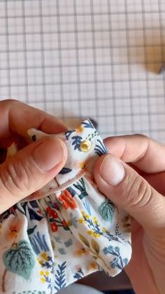 someone is holding a small cloth doll in their left hand and sewing it on the right