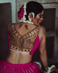 a woman in a pink dress with tattoos on her back