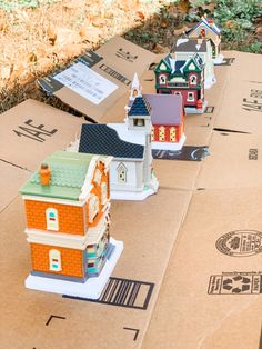 several model houses are sitting on top of cardboard boxes