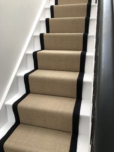 a set of carpeted stairs with black trim