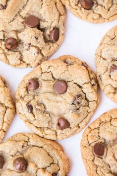 chocolate chip cookies are arranged on a white surface