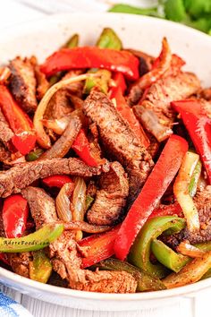 a white bowl filled with meat and peppers