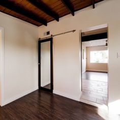 an empty room with hard wood floors and white walls