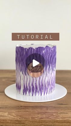 a purple and white cake sitting on top of a wooden table